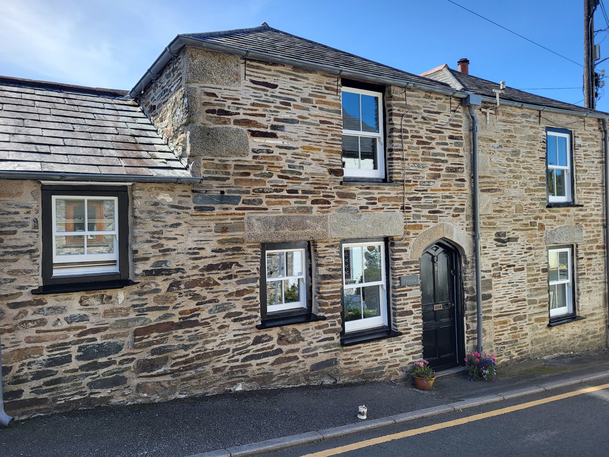 Stone-fronted cottage with freshly painted black windows and front door
