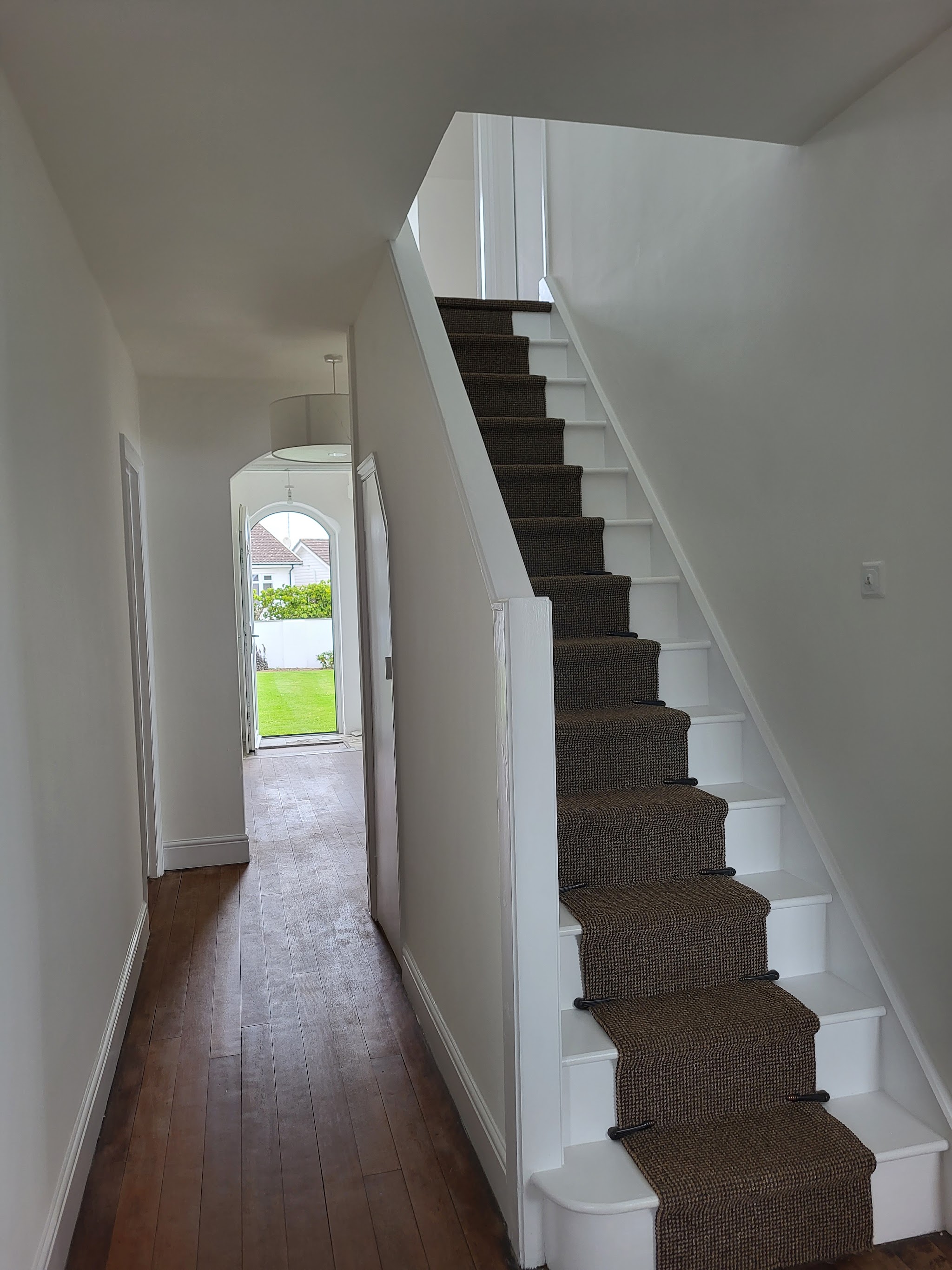 White hallway and staircase with painted spindles