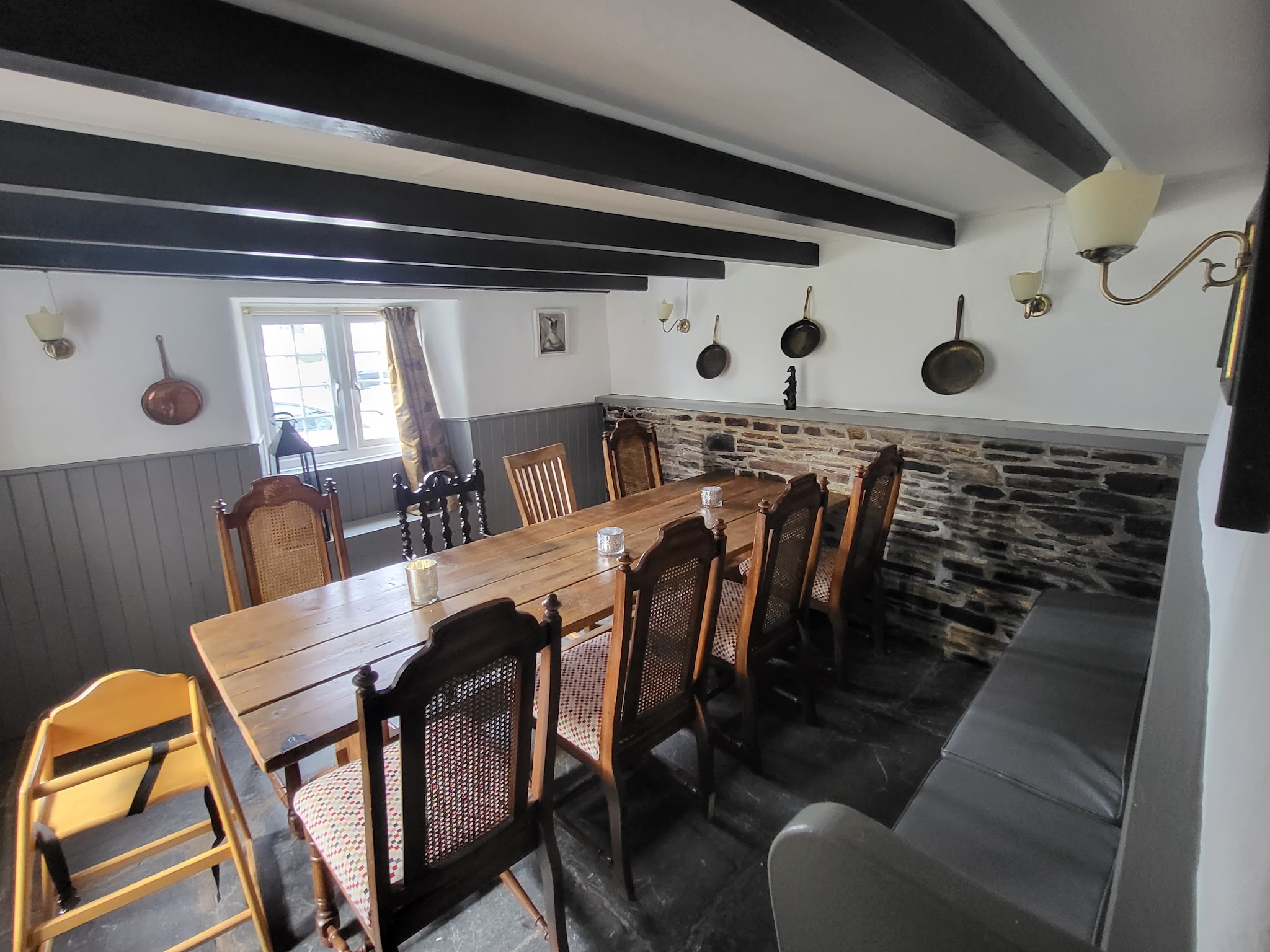 Beamed dining room with grey panelling and white walls