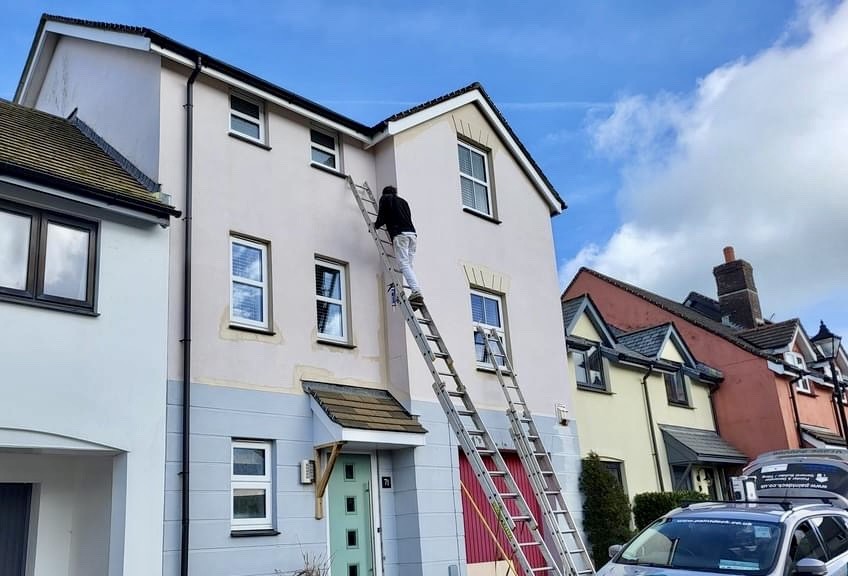 Exterior repaint of a three storey terrace in progress, ladders up to the top floor