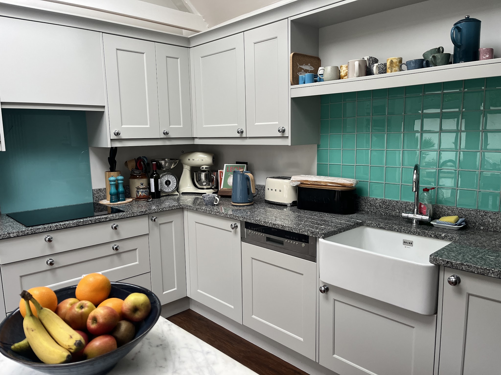 Kitchen with grey cabinets and teal tiles